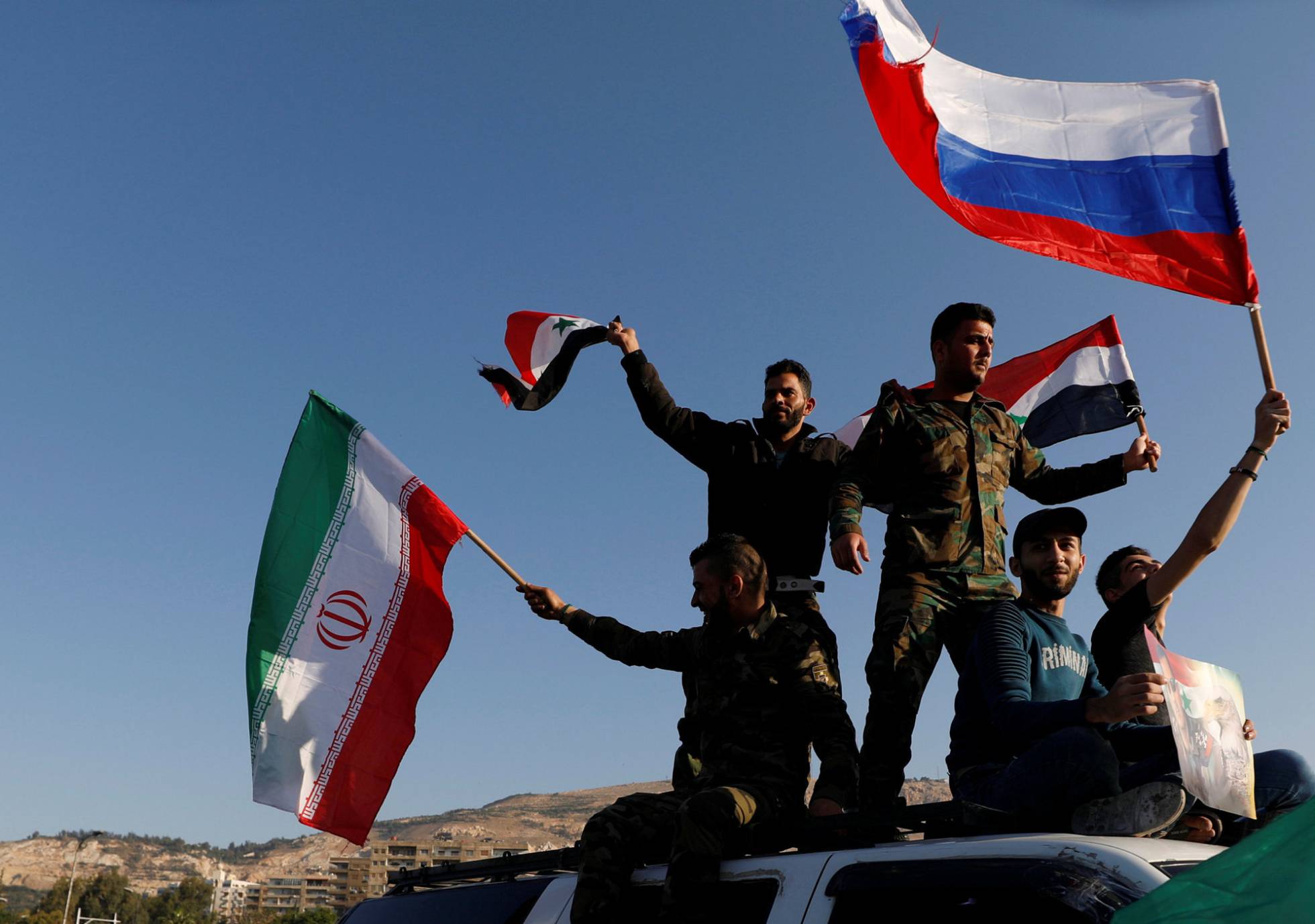 Tropas sirias con banderas de Rusia e Irán